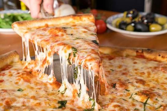 Hand-stretched cheese pizza with fresh basil at Nonna's Place